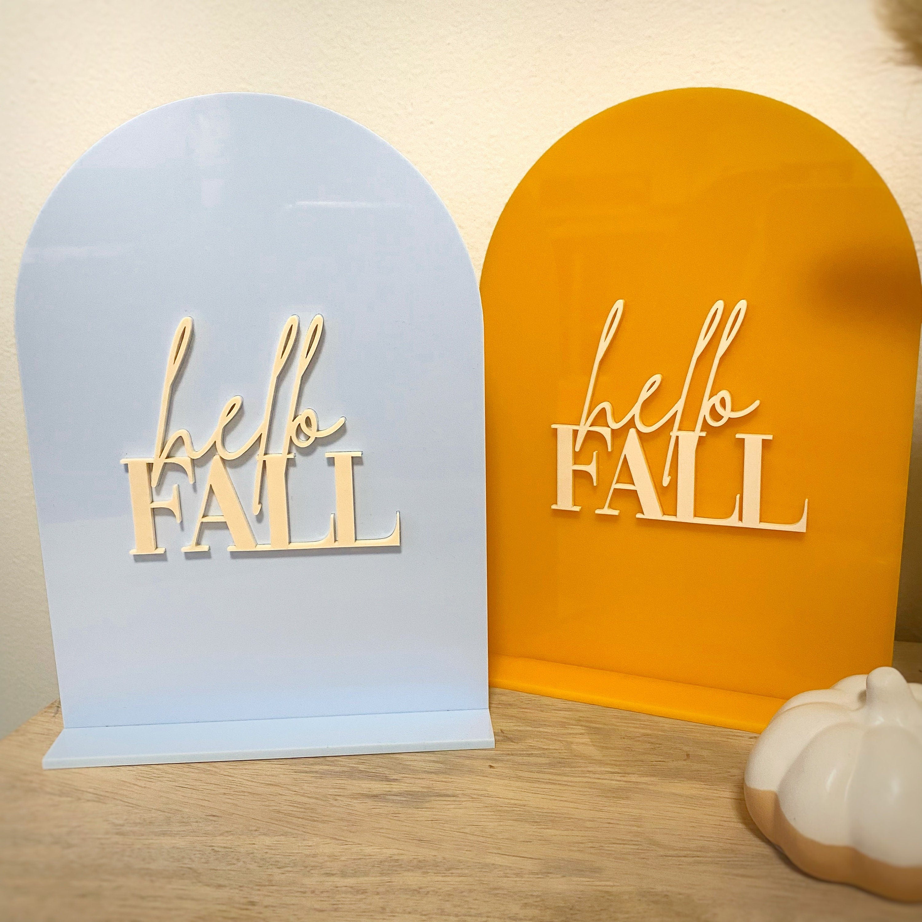 Orange yellow and sky blue acrylic table sign that reads hello Fall in cream letters 