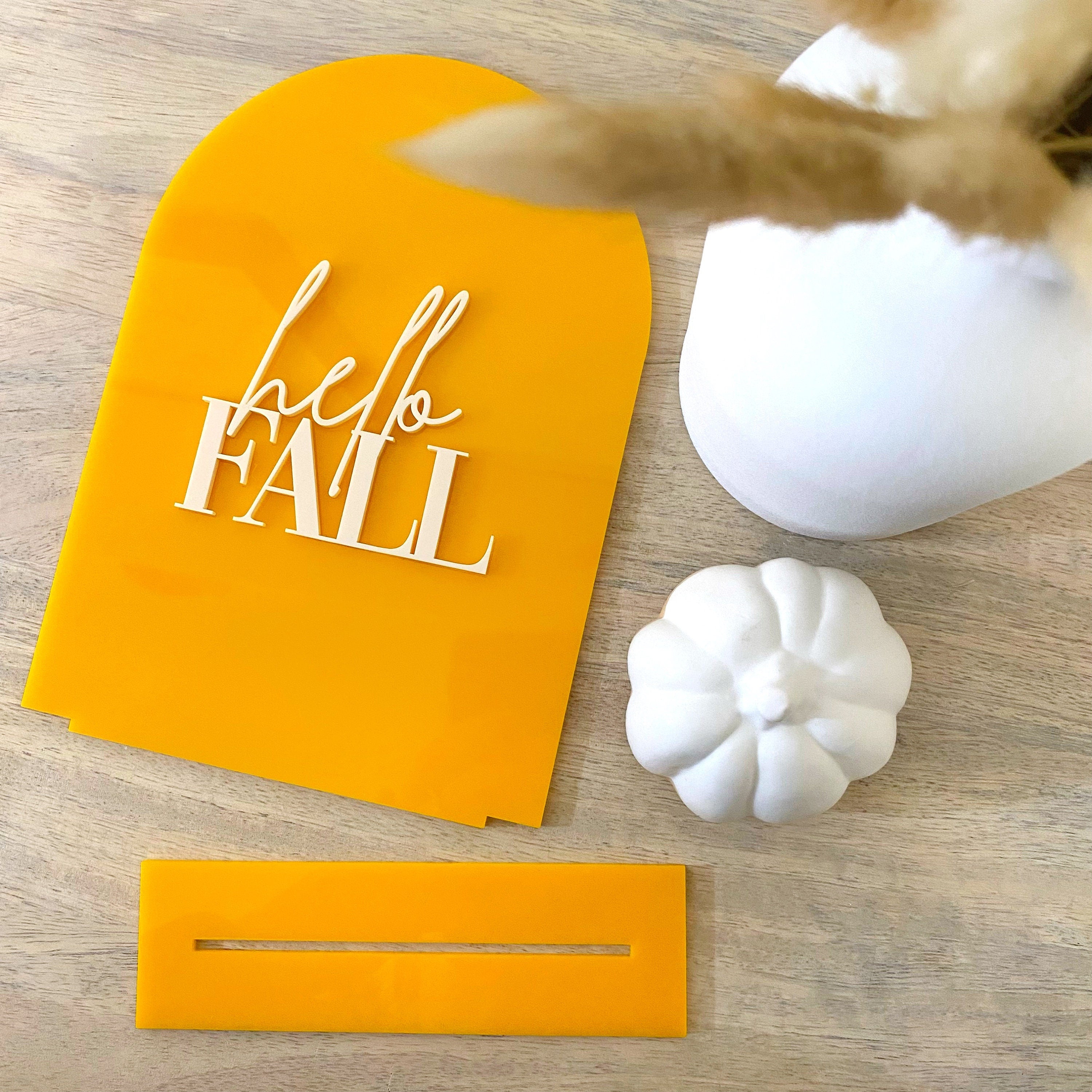 Orange yellow acrylic table sign that reads hello Fall in cream letters 