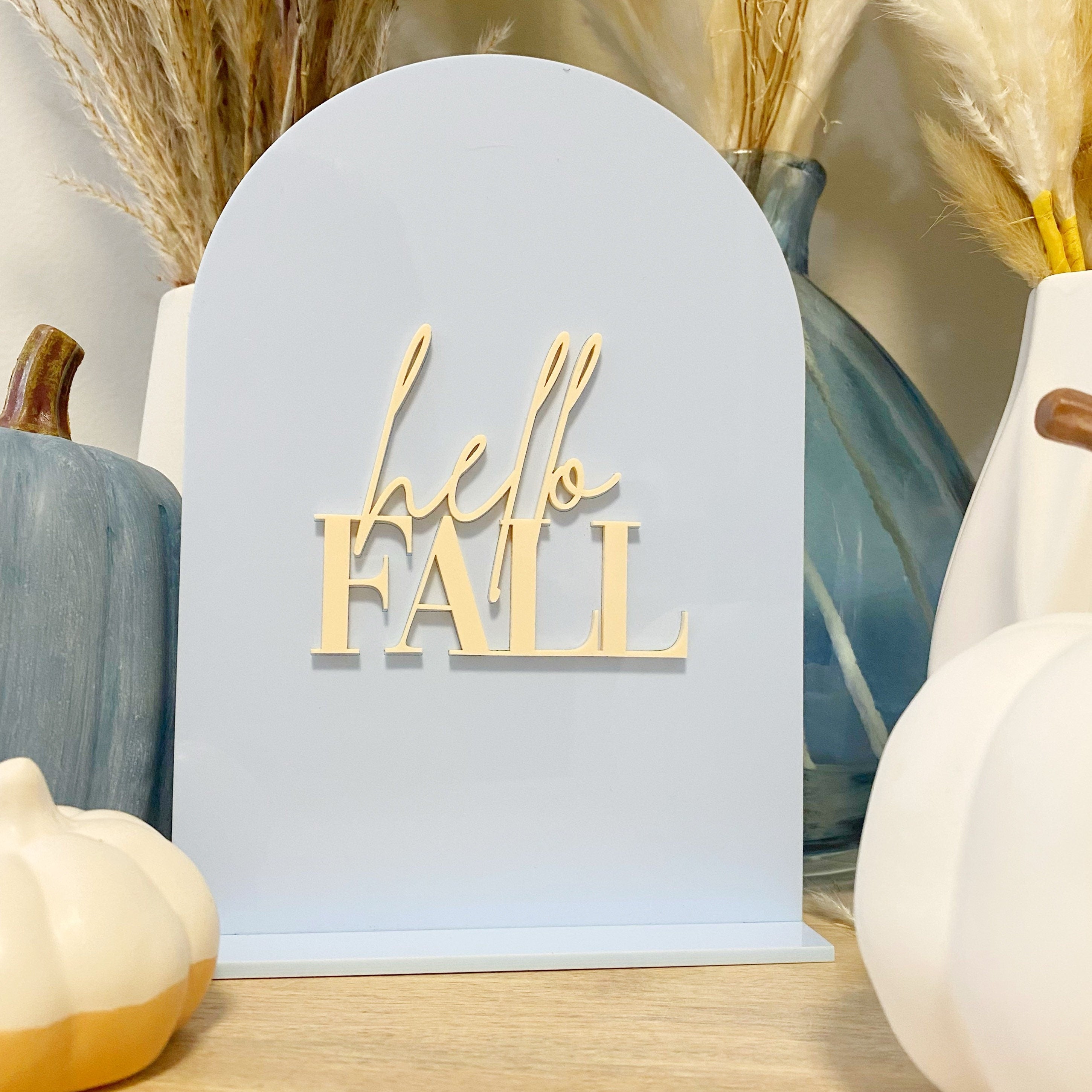 Sky blue acrylic table sign that reads hello Fall in cream letters 